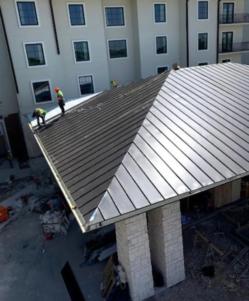 Crew installing standing seam metal roof panels on a commercial project in Harrington Park